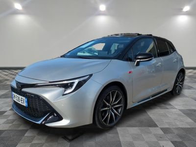 une Toyota Corollion argentée garée dans une pièce au sol à carreaux