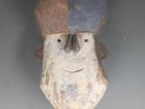 une sculpture en bois représentant un homme portant un chapeau sur la tête