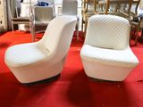 two white chairs that are sitting on a red carpet