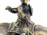 a figurine of a boy sitting on top of an apple