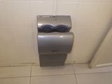 un distributeur de papier toilette dans un coin des toilettes