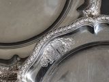 two silver trays sitting on a black table