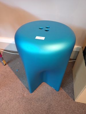 un tabouret bleu posé dans un coin de la pièce