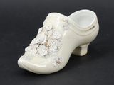 a small white shoe that is on a black surface
