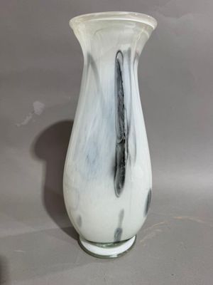 a white and black vase sitting on a table