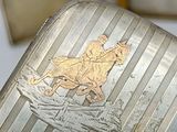 a silver case with a picture of a man on a horse on it