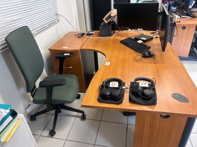 a desk with a computer and a chair in a room