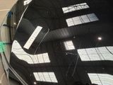 a reflection of a building on the windshield of a car
