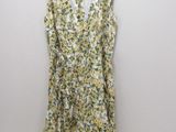 a yellow and white floral dress hanging on a hanger