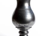 a black vase that is sitting on a white surface