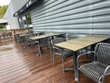 des tables et des chaises sur une terrasse en bois à l'extérieur d'un restaurant