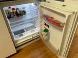 an open refrigerator in the corner of a kitchen