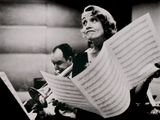 photographie en noir et blanc d'une femme tenant une partition