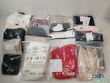beaucoup de vêtements rangés dans des sacs posés sur la table