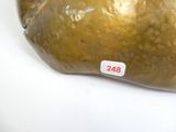 une sculpture dorée représentant un rocher sur un fond blanc