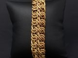 a close up of a gold bracelet on a black pillow
