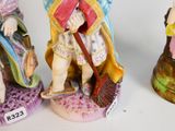 three figurines of a man with a broom and a woman with a hat