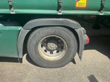 a green truck with a flat tire parked in a parking lot