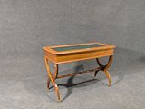 a small wooden table with a glass top on a gray surface