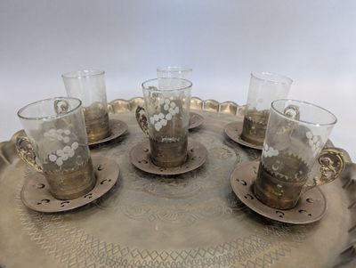 quatre verres posés sur un plateau en argent, sur une table blanche