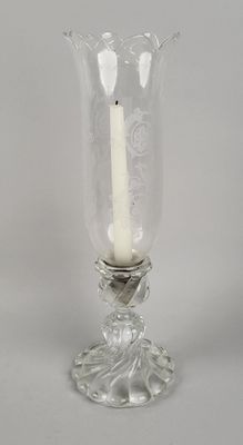 un vase en verre contenant une bougie allumée