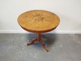 une petite table avec un plateau en bois sur un sol en ciment