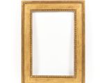 a gold picture frame on a white wall with a white background