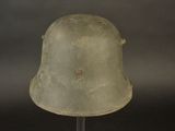 an old military helmet on a metal stand against a black background