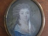 a miniature picture of a woman in a blue dress on a table