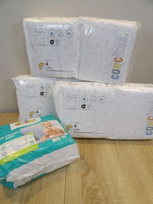 three packs of baby diapers sitting on top of a wooden table