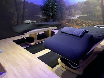 two massage beds in a room with a painting on the wall