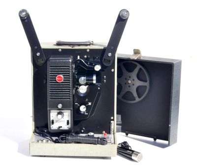un vieux projecteur de cinéma posé sur une surface blanche