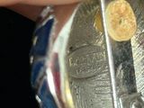 a person holding a silver and gold coin in their hand