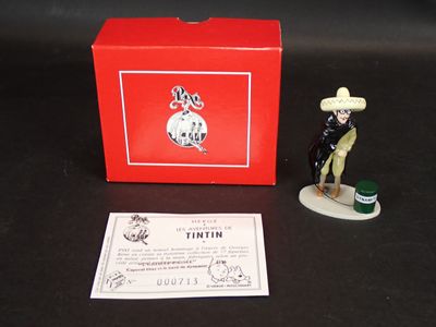 une petite figurine représentant un homme coiffé d'un chapeau, accompagnée d'une boîte rouge