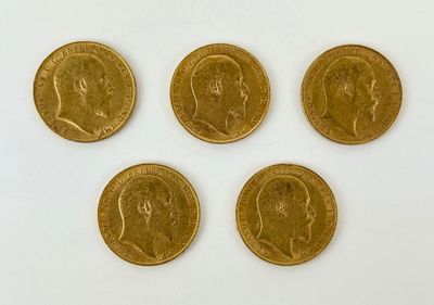 four gold coins of different sizes and shapes on a white surface