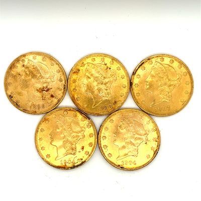 quatre pièces d'or sont disposées en ligne sur une surface blanche