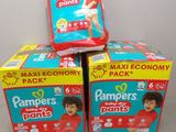 trois boîtes de couches empilées les unes sur les autres sur une table