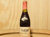 une bouteille de vin posée sur un tonneau en bois