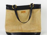 un sac à main beige et noir avec des anses noires sur fond blanc
