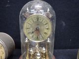 a clock inside of a glass dome on a table