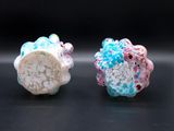 pair of colorful glass beads on black surface with black background