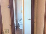 a mirror in the corner of a room with a chair in front of it
