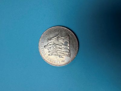 un gros plan d'une pièce d'argent posée sur une surface bleue