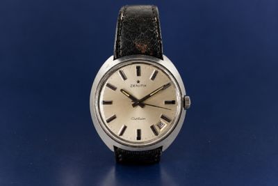 a close up of a wrist watch on a blue surface