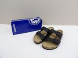 the black sandals are next to a blue box on a white surface