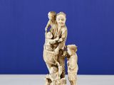 carved ivory figurine of a man and child on a rock