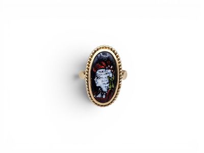 a gold ring with a black and red stone in the center