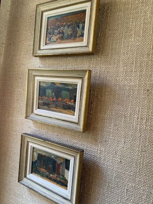 trois tableaux encadrés accrochés au mur d'une pièce