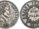 a silver coin with a woman ' s face and laurels on it