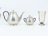 five silver vases and a silver teapot on a white background